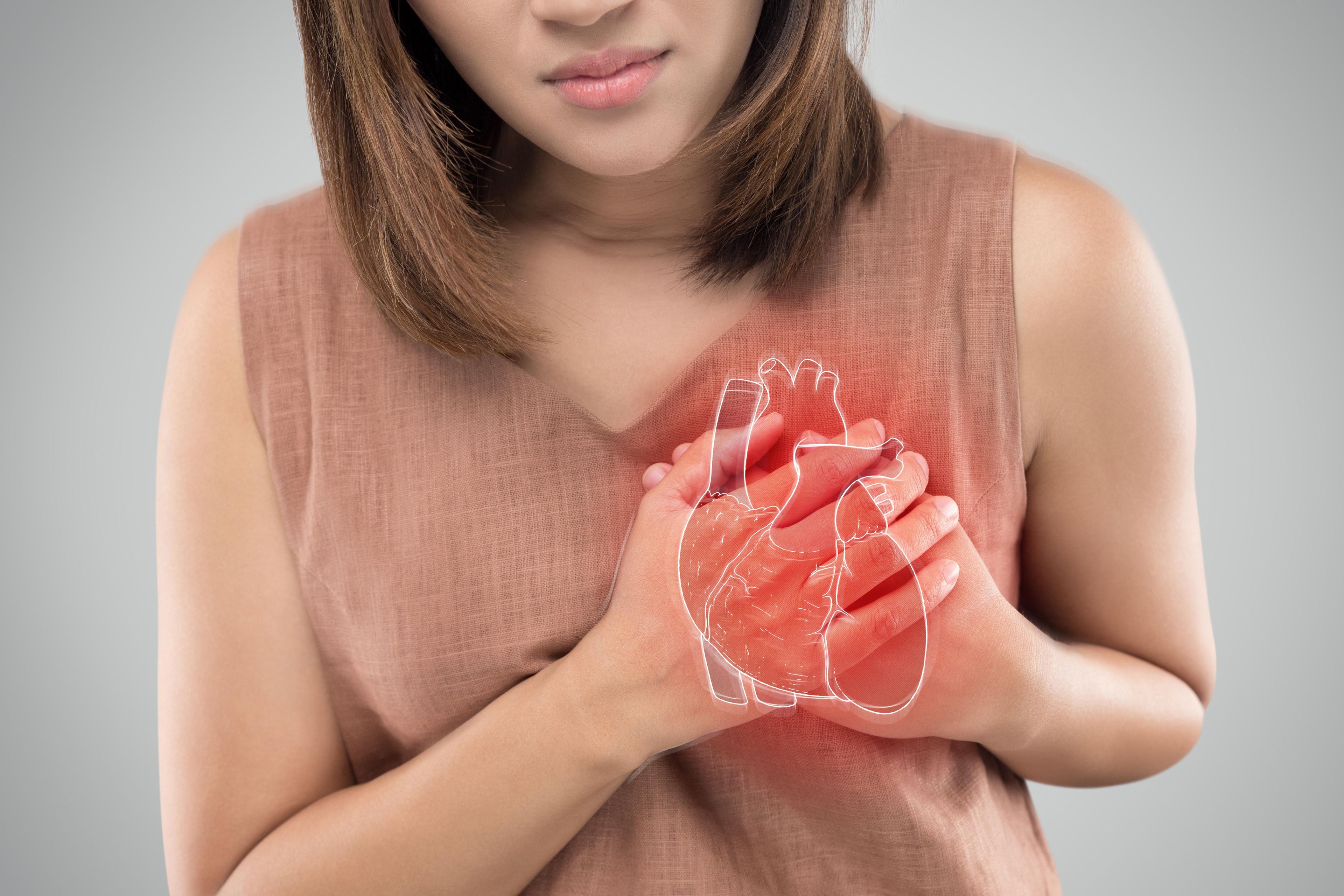 Woman holding hand to heart in pain | Image credit: eddows – stock.adobe.com