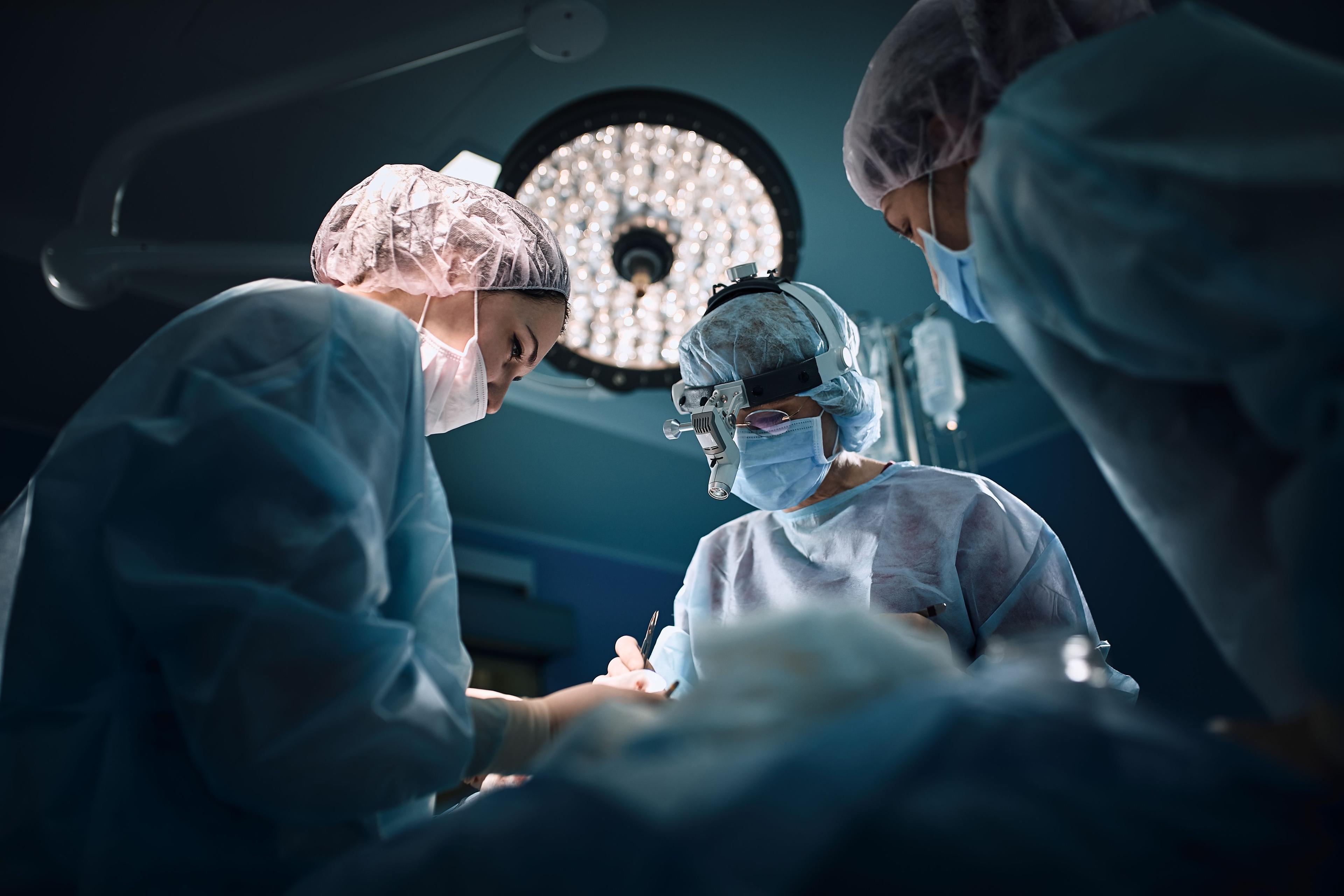 medical team in operating room | Image Credit: Georgii - stock.adobe.com