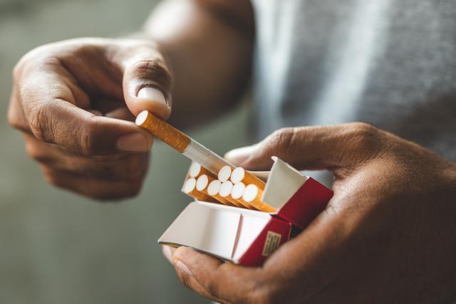 Man reaching for cigarette | Image Credit: Nopphon - stock.adobe.com