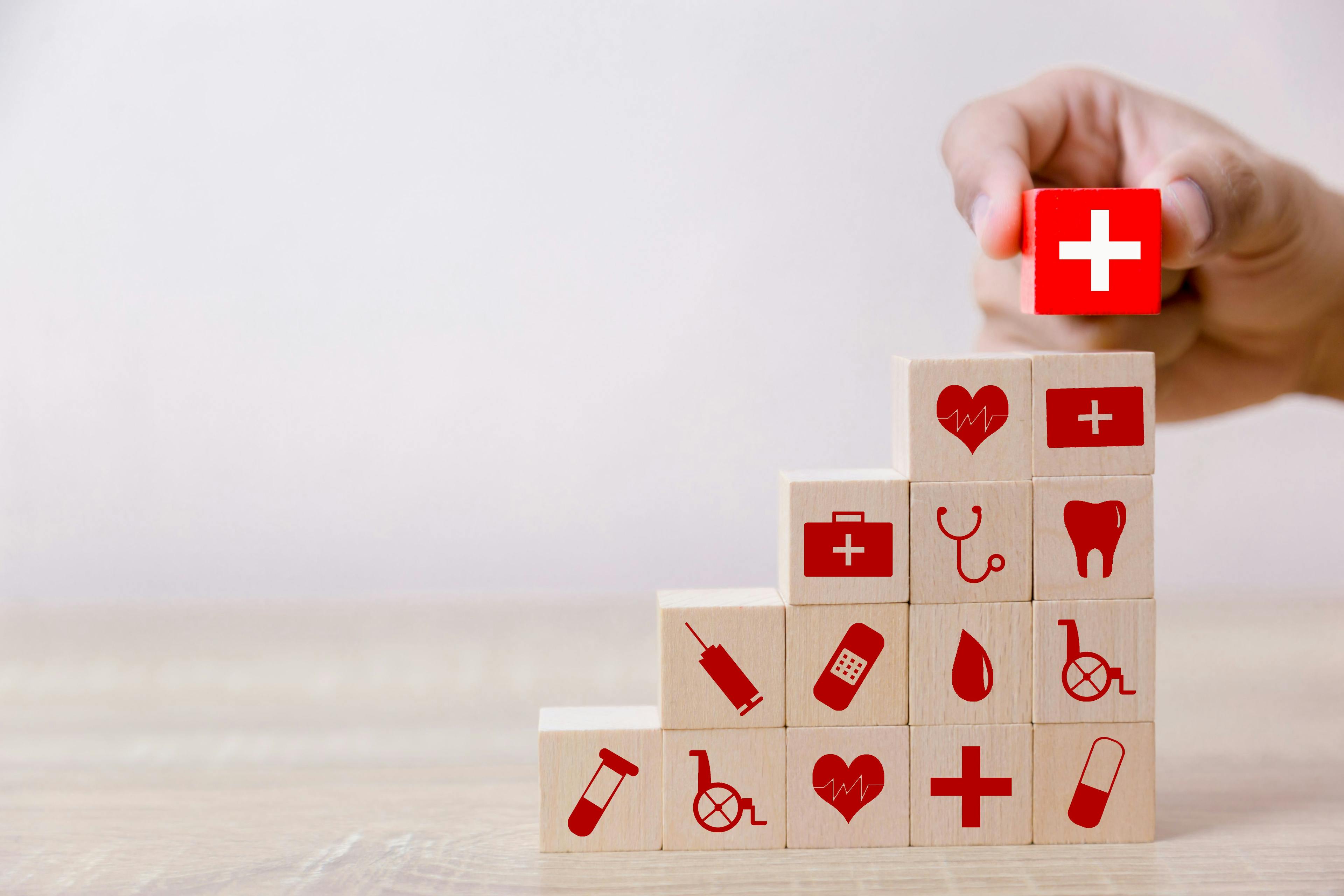 Stack of wood blocks with insurance and health care icons | Image credit: A stockphoto - stock.adobe.com