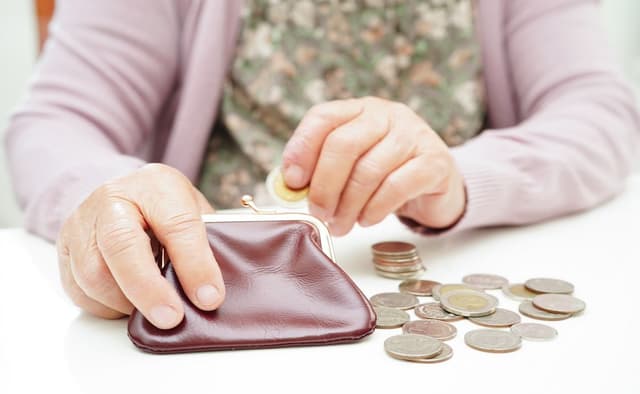 Retired woman counting coins | Image Credit: © manassanant-stock.adobe.com