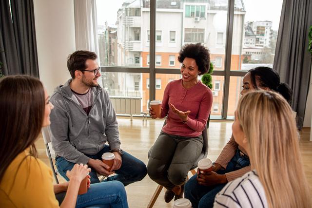 Diverse group of people sitting in circle in group therapy session - Zoran Zeremski - stock.adobe.com