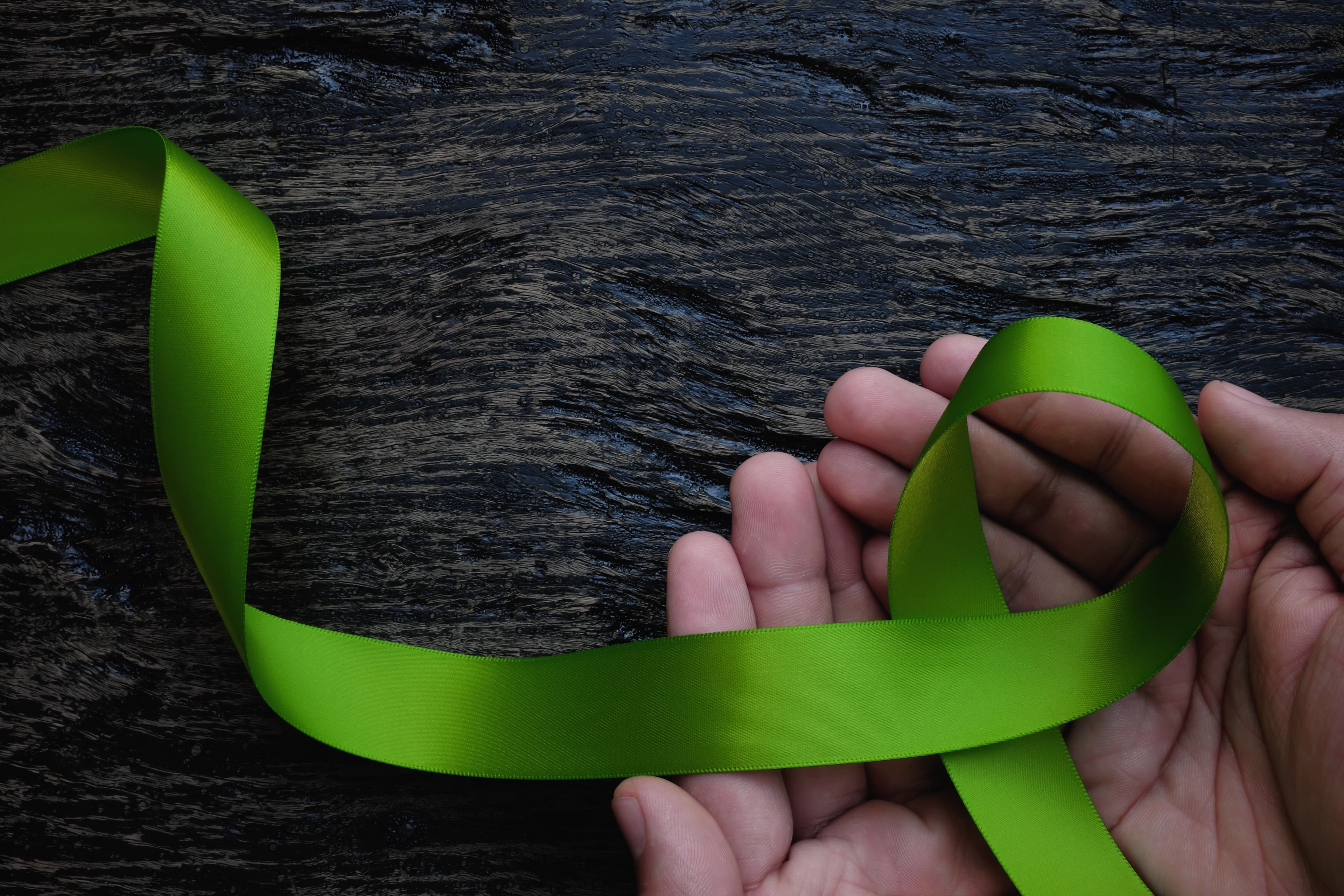 Hands holding green lymphoma ribbon | Image credit: sulit.photos - stock.adobe.com