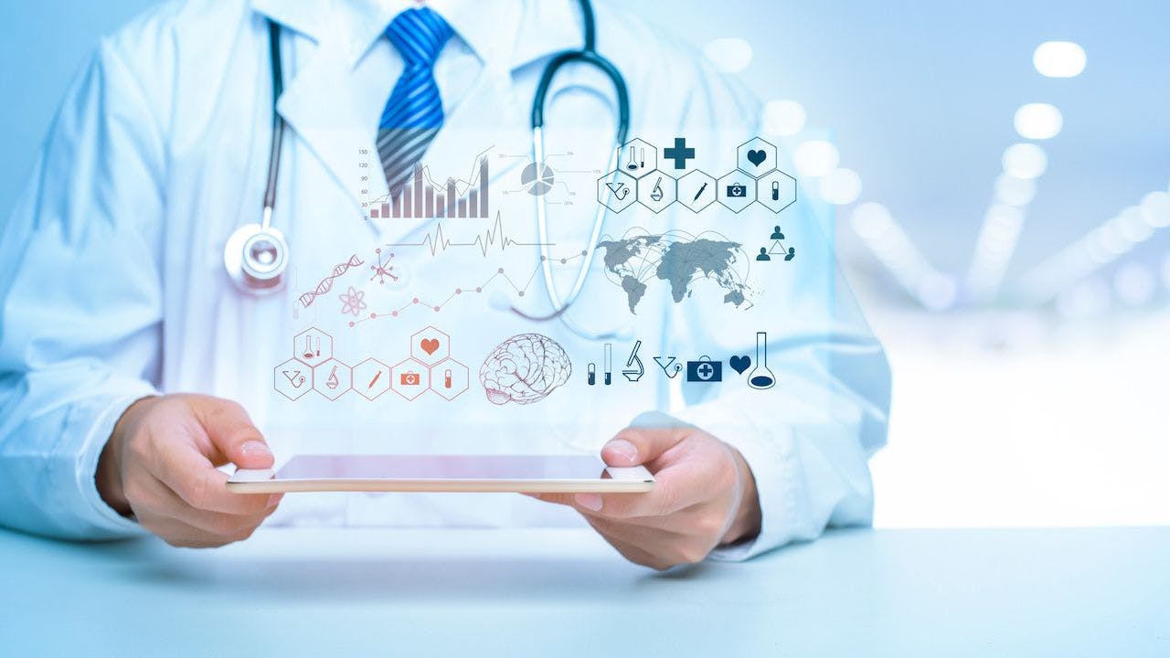 Medical data analytics floating above a device held by a doctor | Image credit: tonefotografia - stock.adobe.com