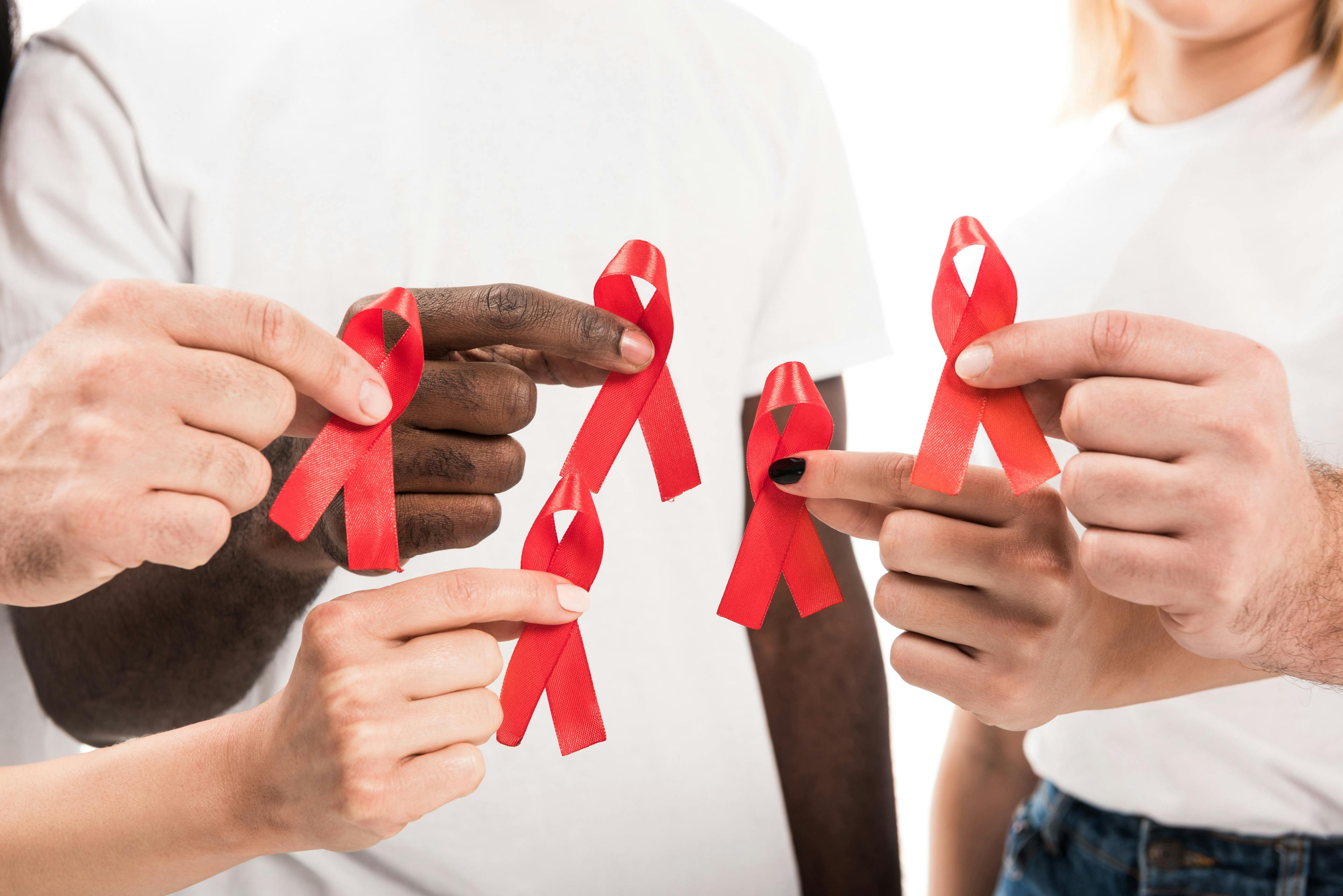 People in blank white T-shirts holding AIDS awareness red ribbons. | Image credit: LIGHTFIELD STUDIOS - stock.adobe.com