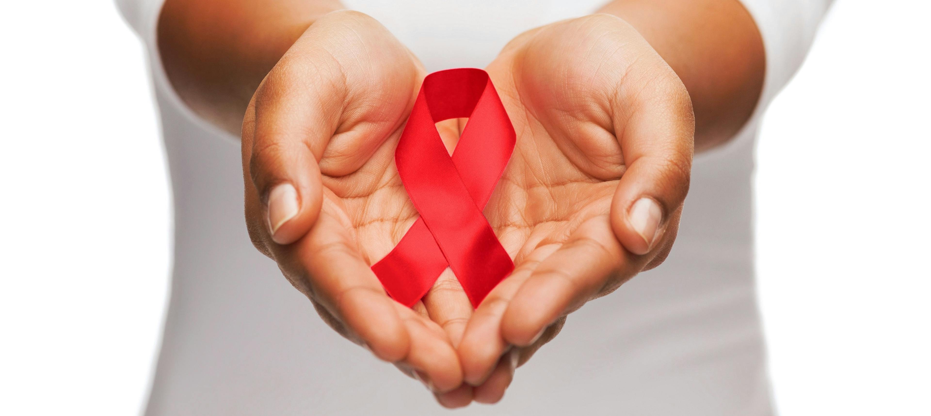 Hands holding HIV/AIDS awareness ribbon | Image credit: Syda Productions - stock.adobe.com