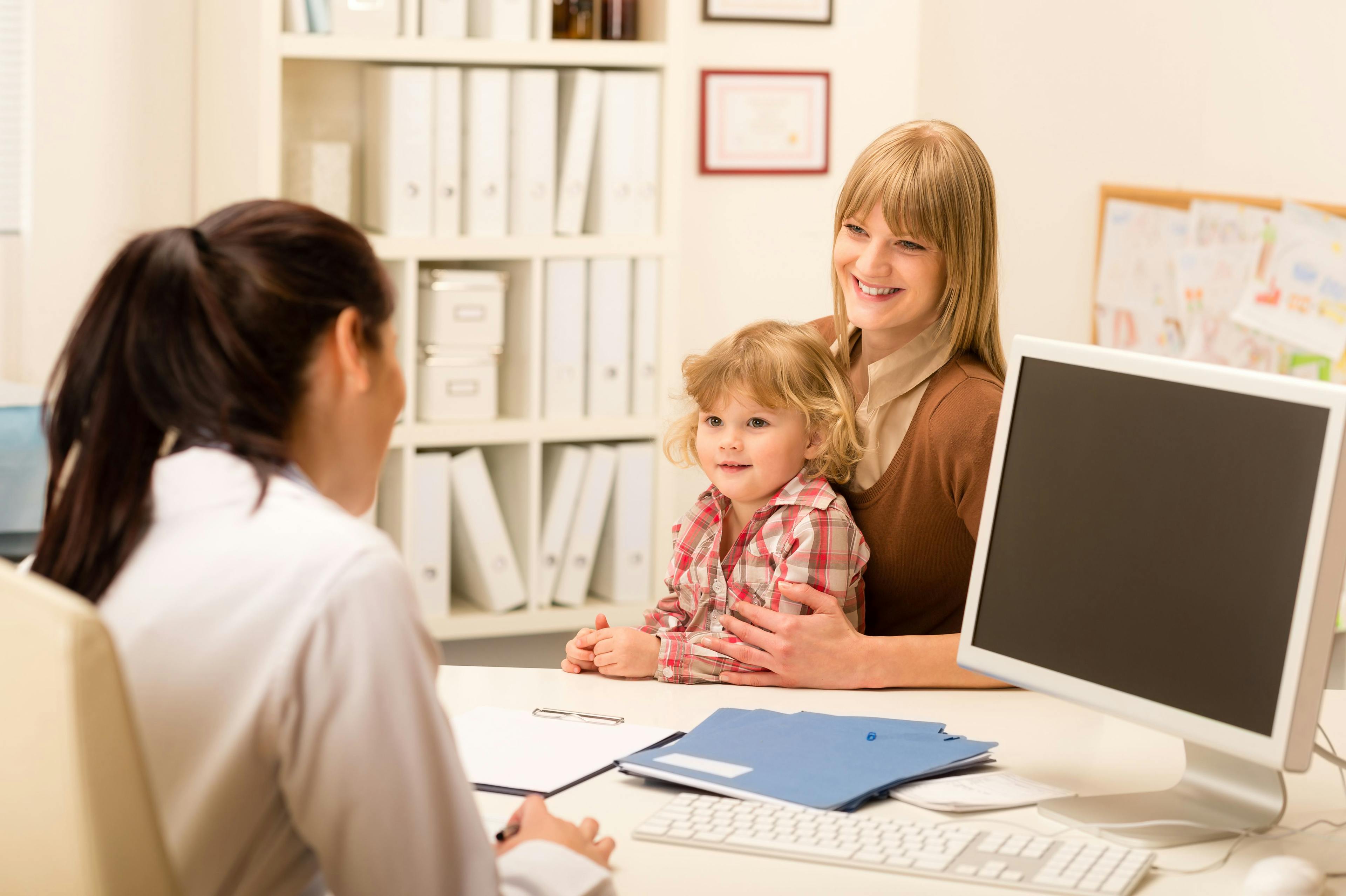 a doctor is speaking to a child and adult woman
