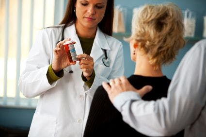 Physician showing prescription to patient and caregiver.