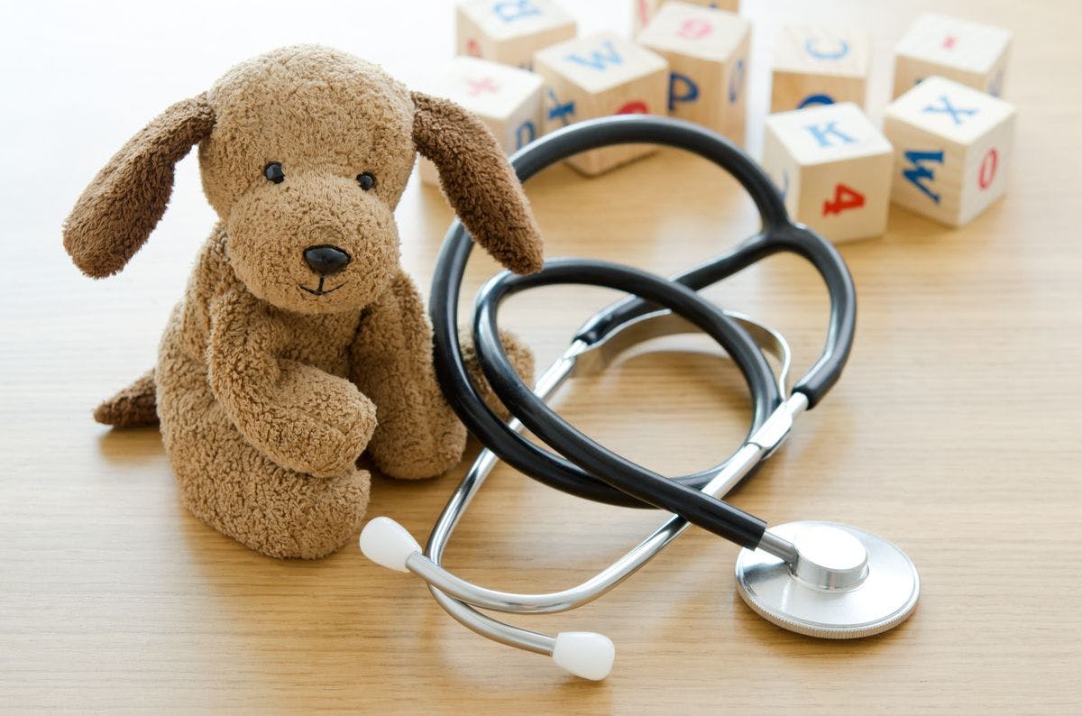Stethoscope next to a teddy bear and blocks.