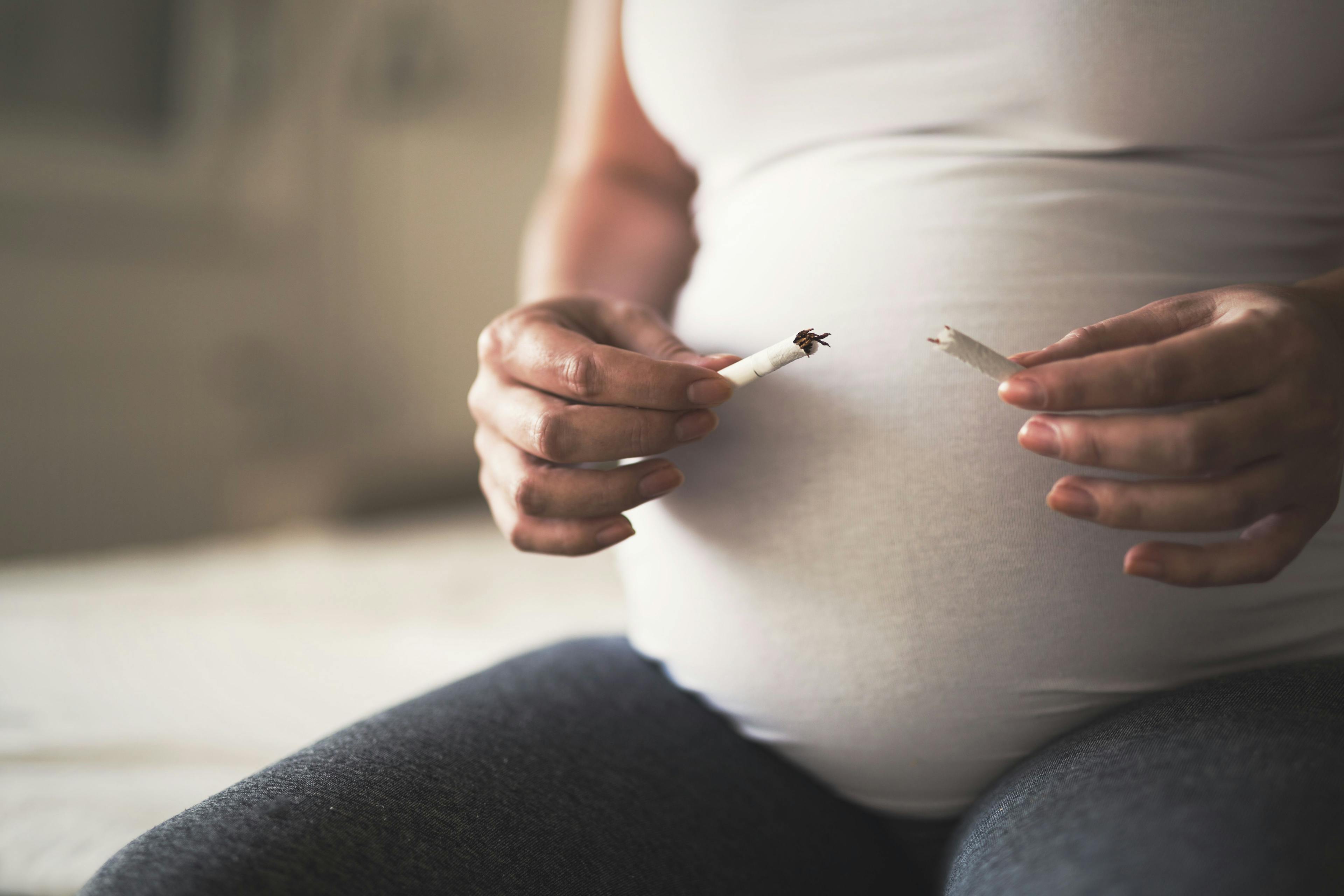 Pregnant Woman Breaking Cigarette | image credit: NDABCREATIVITY - stock.adobe.com