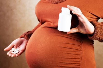 pregnant woman holding a bottle of pills