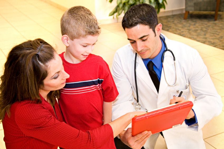 a mother and child are speaking to a doctor on a tablet