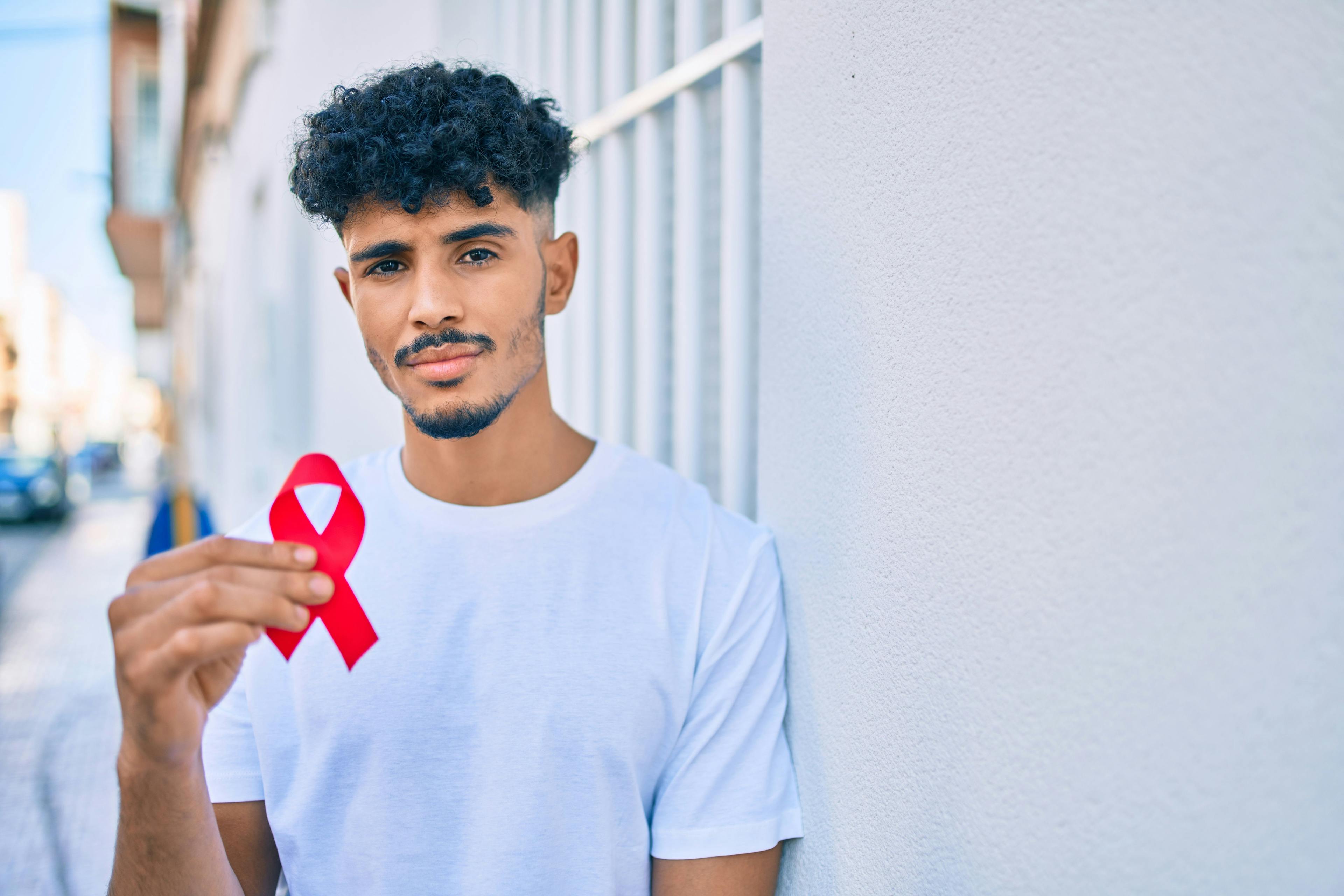 Young man holding HIV awareness ribbon | Image credit: Krakenimages.com - stock.adobe.com