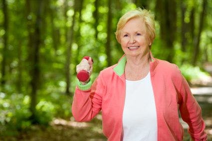 woman walking through forest with holding weights