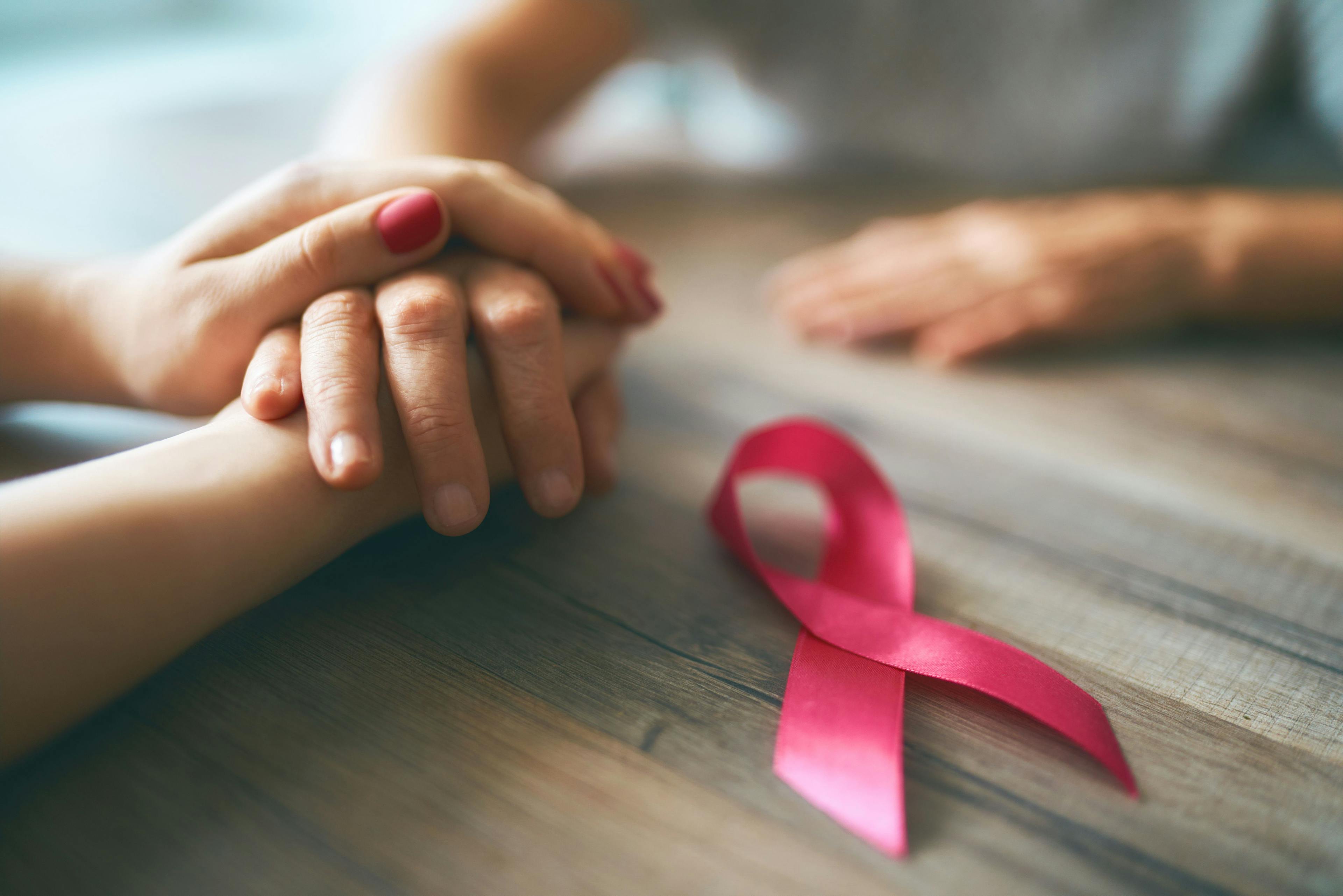 Woman hands with breast cancer ribbon. | Image Credit: Konstantin Yuganov - stock.adobe.com